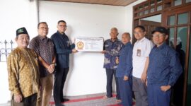 Direktur Manajemen Human Capital dan Administrasi PLN NP TB Ari Wibawa Mukti  (ketiga dari kiri) bersama Sutarno (keempat dari kiri) memegang plakat yang menjadi penanda selesainya renovasi rumah purna  karya PLN NP tersebut.